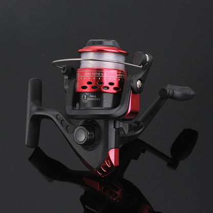 Fishing reel with red and black design on a reflective black surface