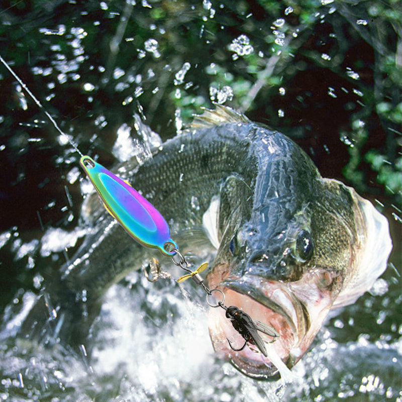Largemouth bass with a colorful fishing lure in its mouth, surrounded by water droplets.